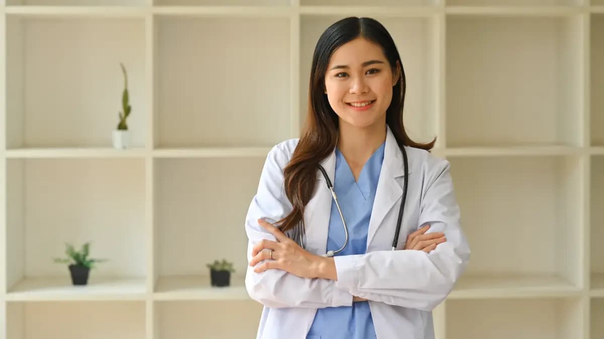 A smiling healthcare professional standing in a workplace.